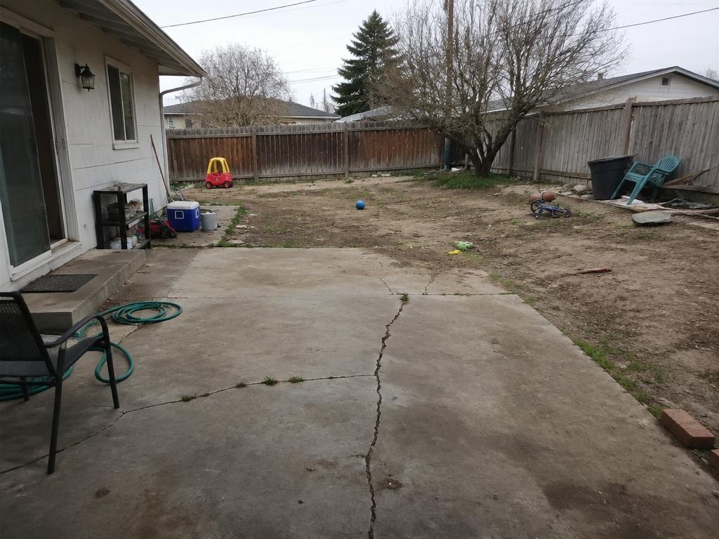 Cracked concrete patio before, and a new paver patio with fire pit at dusk after